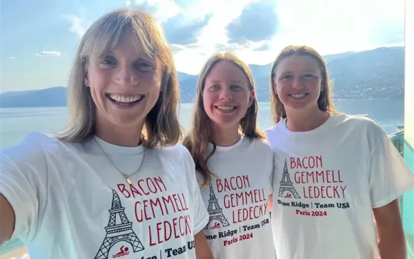 Las integrantes del equipo de natación de Estados Unidos y ex alumnas de Stone Ridge Katie Ledecky, Erin Gemmell y Phoebe Bacon posan con camisetas personalizadas de su alma mater. Competirán en los Juegos Olímpicos de París del 26 de julio al 11 de agosto de 2024. Crédito: Escuela Stone Ridge del Sagrado Corazón.