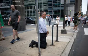 Un hombre se arrodilla al paso de la Procesión Eucarística Nacional en Filadelfia, el 30 de mayo de 2024. Crédito: Jeffrey Bruno.